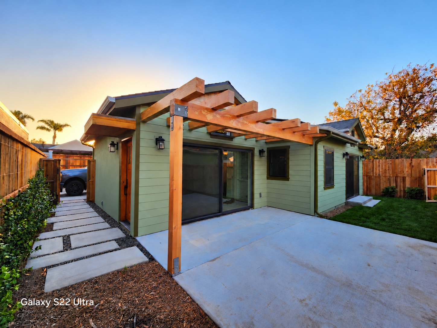 Burbank ADU with green siding, timber pergola, and concrete patio