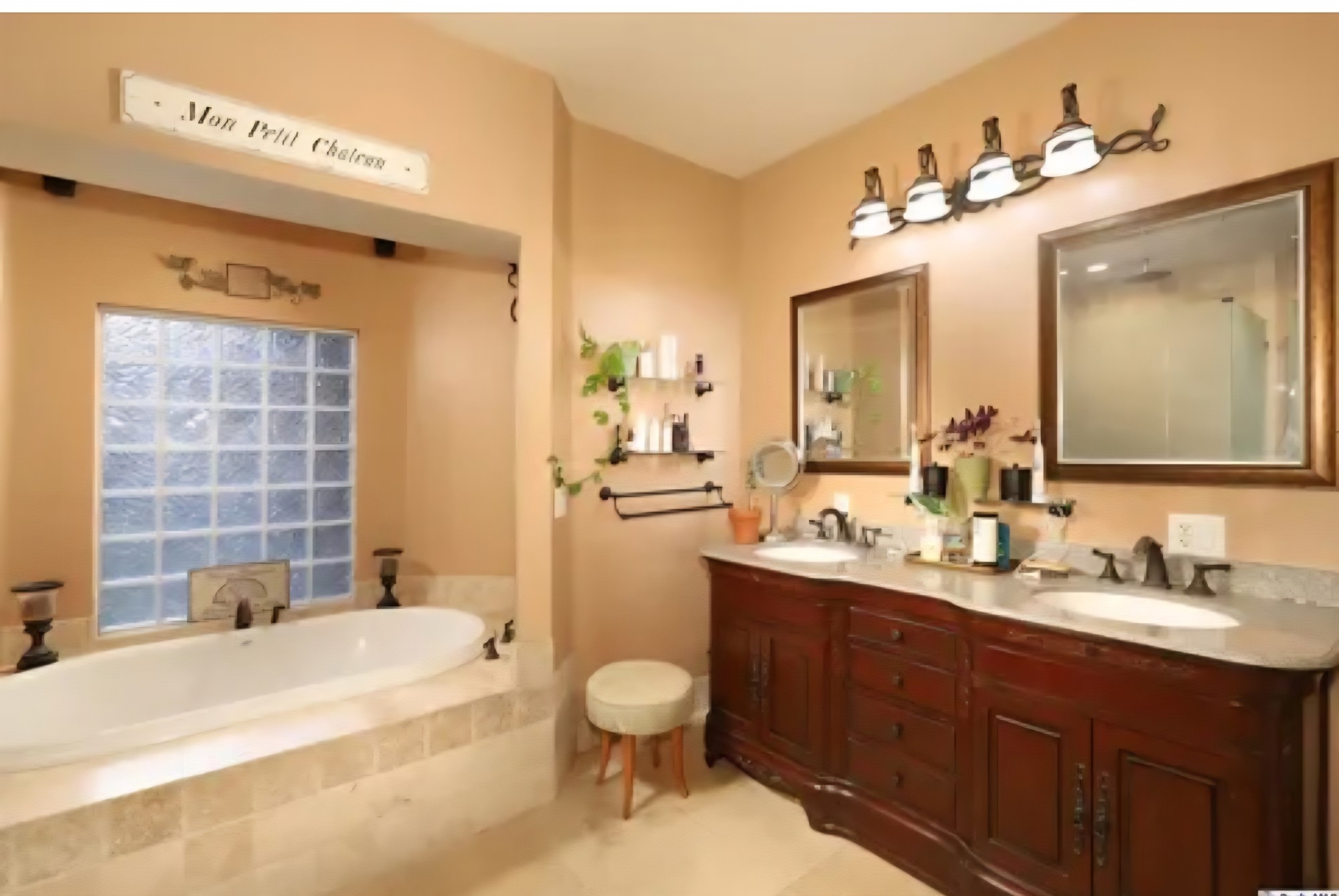 Bathroom with a soaking tub, glass-block window, and double vanity