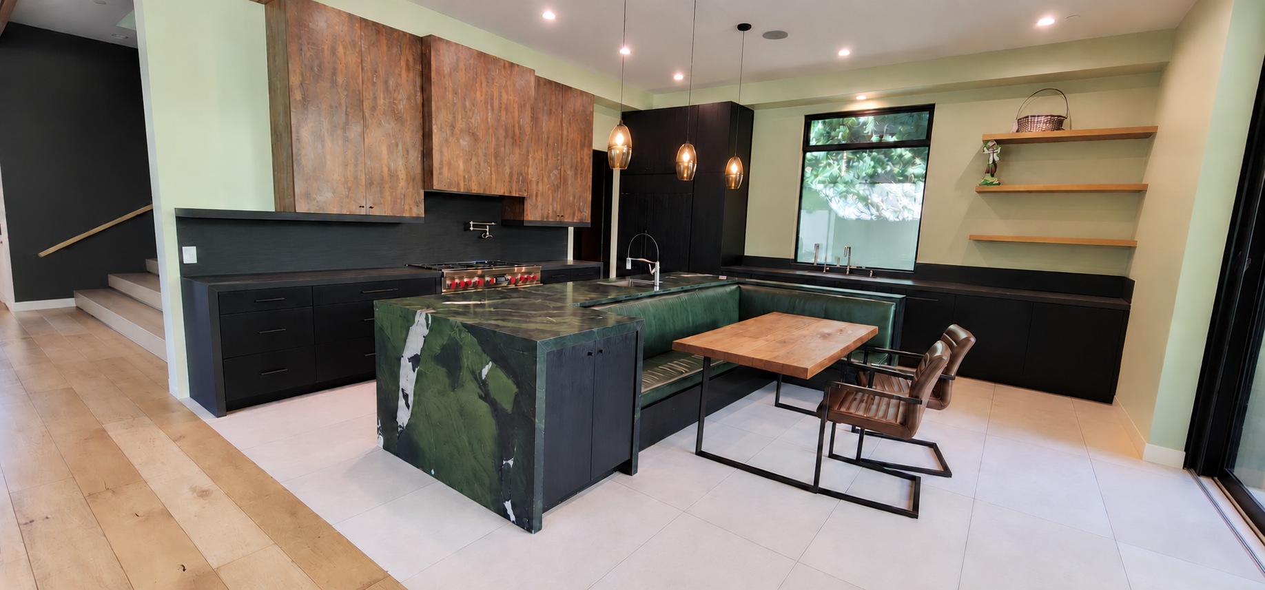 Hartsook kitchen with a green stone island, warm wood cabinetry, pendant lighting, and built-in dining nook