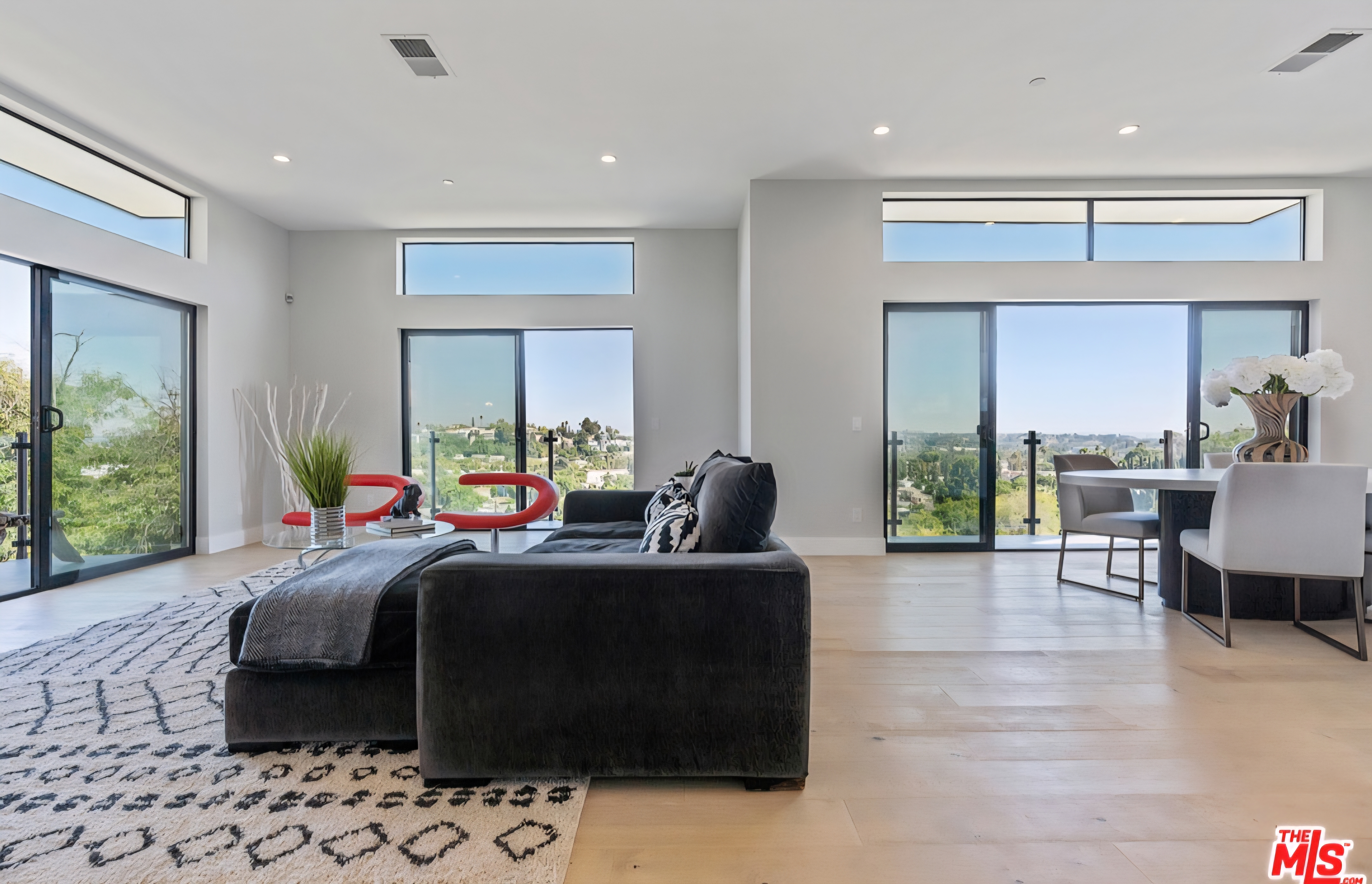 Richard Circle Dr living and dining area with tall windows, light wood flooring, and hillside views